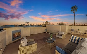 A rooftop terrace with a fire feature, seating, and a view of the sunset. - Steps to Mission Bay! 2BR Townhome w/Roof Deck, Sea World Drone Show & Bay Views (San Diego)