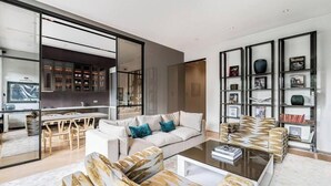A modern living room with a sofa, coffee table, and a bookshelf.