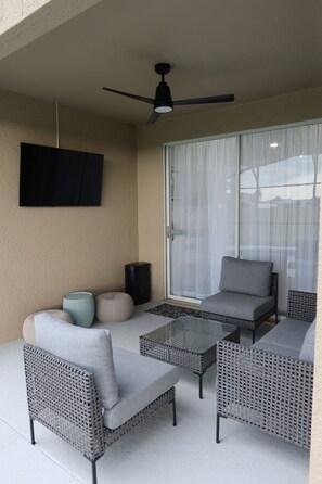 A covered patio area with outdoor furniture, including two sofas and two armchairs, a coffee table, and a ceiling fan. - Minutes from the Magic .Private Pool • Harry Potter Game Room • Sleeps 10 (Davenport)