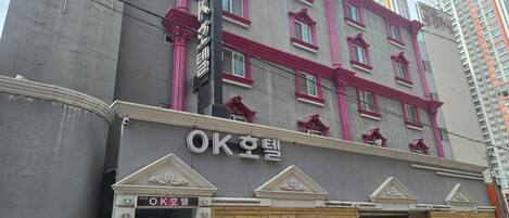 A hotel with a prominent sign, a gated entrance, and a modern facade.