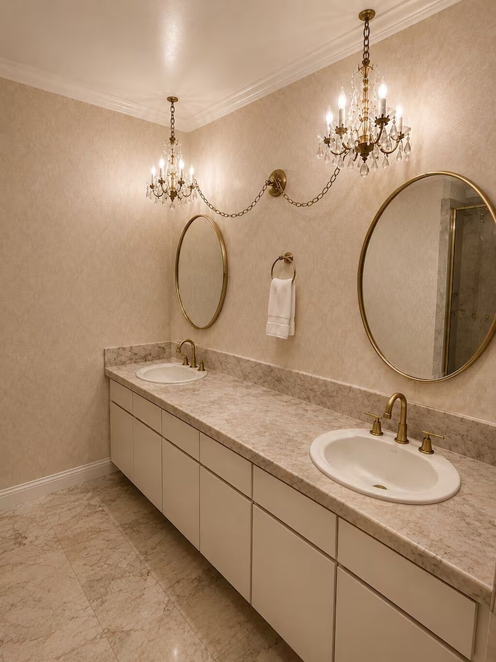 A bathroom with two sinks, a large mirror, and a chandelier.