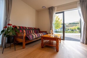 Una habitación con sofá, una mesa de centro y una planta en maceta.