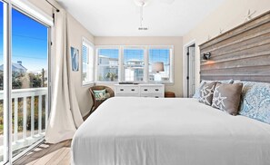 A bedroom with a large bed, a dresser, a chair, and a window with blinds. - My Blue Sky - Fire Pit, Neighborhood Beach Access! (Santa Rosa Beach)