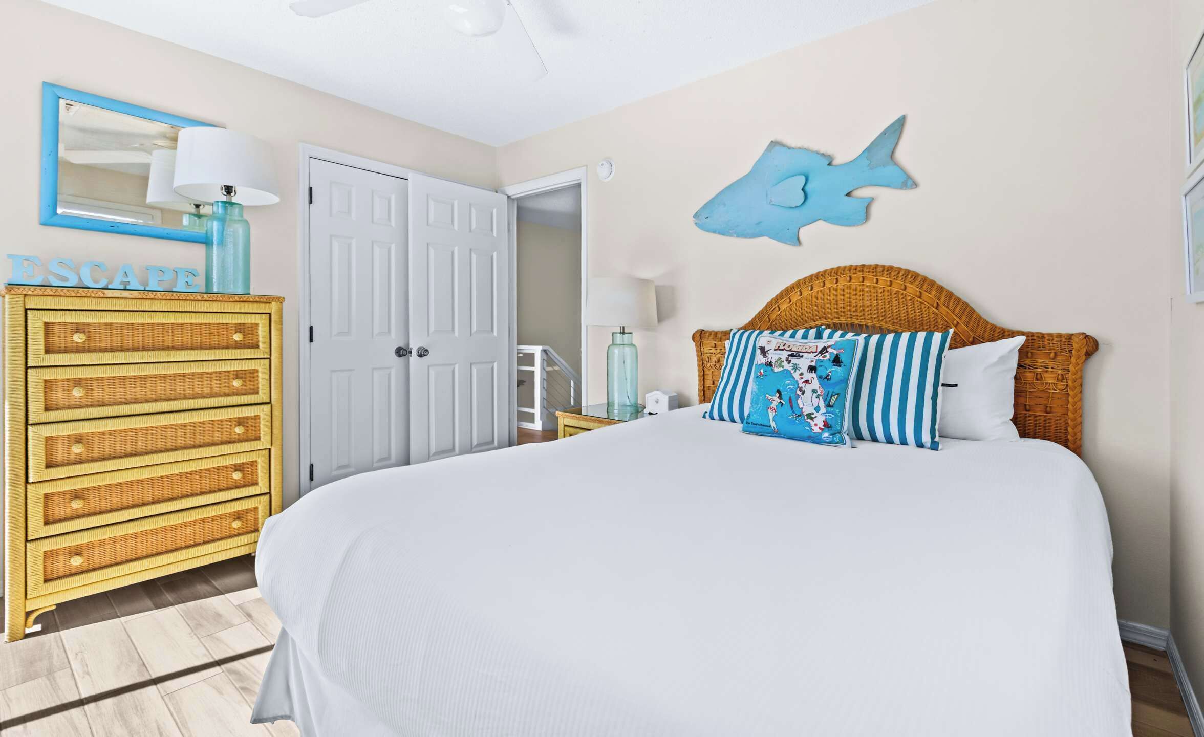A bedroom with a bed, a dresser, a door, and a wall decoration.