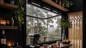 Een gezellig interieur van een blokhut, met een koffieapparaat, boeken en een raam met uitzicht op een bos.
