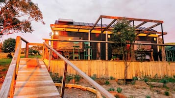 A modern house with a wooden deck and a metal railing.