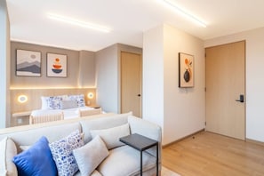 A modern hotel room with a bed, a sofa, a small table, and artwork on the walls. - Myla - 3 - Magnolia Centro Historico (Mexico City)