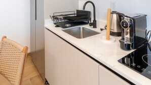 Moderni keittiö, jossa on sisäänrakennettu astianpesukone, kahvinkeitin ja leivänpaahdin.