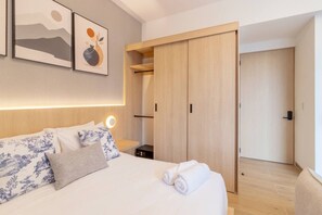 A hotel room with a bed, a wardrobe, a bedside table, and artwork on the wall. - Myla - 4 - Magnolia Centro Historico (Mexico City)