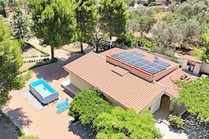 Ein Wohnhaus mit Swimmingpool, Solaranlage und rotem Ziegeldach.