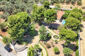 An aerial view of a residential area with a house, a swimming pool, and a car parked on the street. - Villa Armonia Cordis, Sava, Italy (Sava)