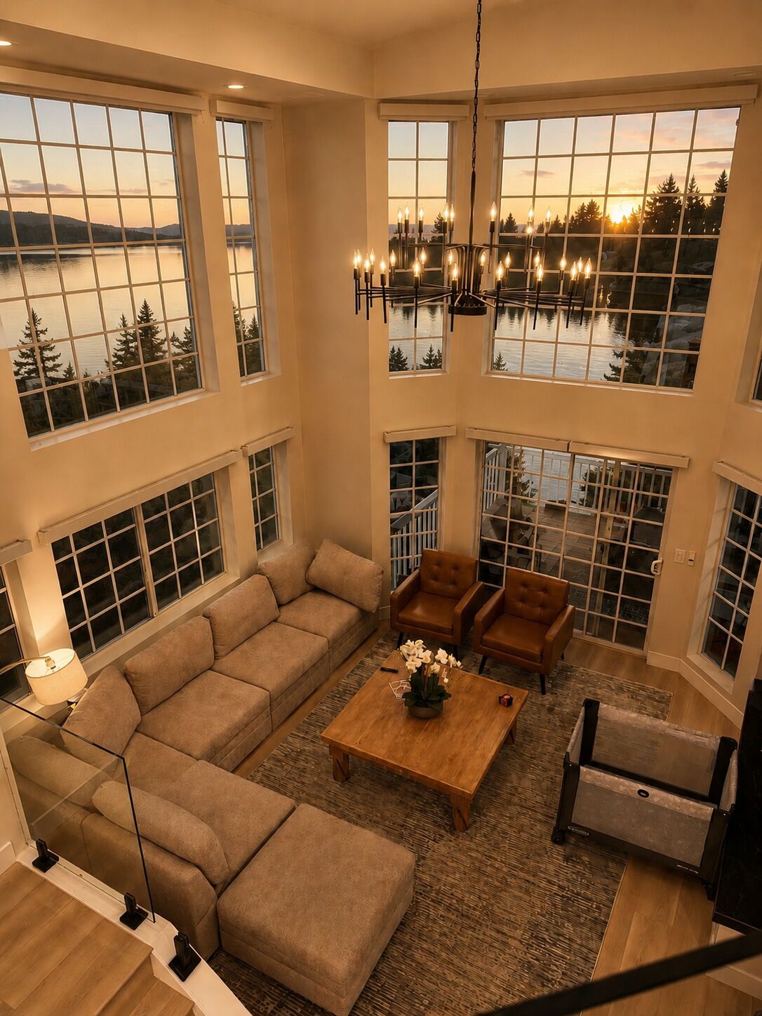 A spacious living area with a large sectional sofa, two armchairs, a coffee table, and a chandelier.