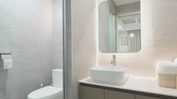 A modern bathroom with a toilet, a sink, and a mirror.