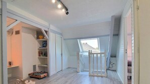 A narrow hallway with a loft bedroom above, a wooden chair, and a small window. - Ty Venoux - ELVEN - Vacation Rental (ELVEN)