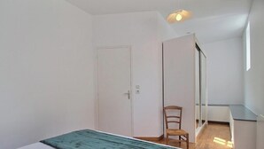 A bedroom with a bed, a chair, a wardrobe, and a mirror. - Ty Venoux - ELVEN - Vacation Rental (ELVEN)