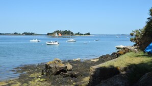 A coastal scene with calm waters, boats, and a rocky shoreline. - Ty Venoux - ELVEN - Vacation Rental (ELVEN)