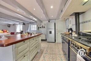 A kitchen with a central island, a refrigerator, a stove, and a sink. - Ty Venoux - ELVEN - Vacation Rental (ELVEN)