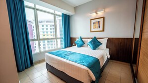 A hotel room with a large bed, a window with curtains, a framed picture on the wall, and a wooden headboard. - Utm Hotel Residence (Kuala Lumpur)