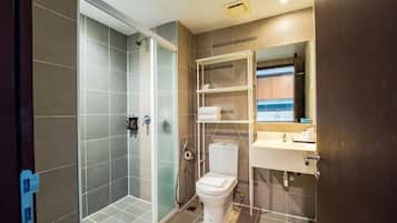 Un baño moderno con ducha, inodoro y lavamanos.