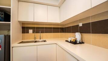 A modern kitchen with a built-in sink, a coffee machine, and a microwave.