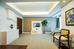 Una sala de estar moderna con un televisor de pantalla plana, un sofá, una mesa de centro y una planta en maceta.