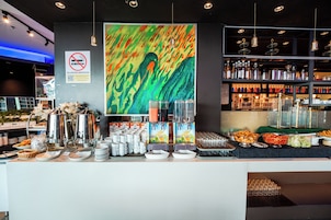 Un café proposant une machine à café, un espace dédié aux thés, ainsi qu’une variété de plats et de boissons.