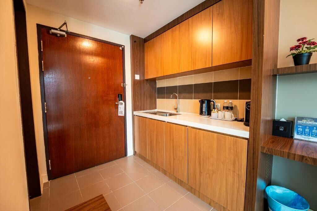 A compact kitchen with wooden cabinets, a sink, and a coffee maker.