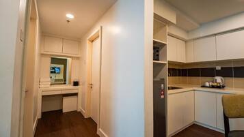 A compact kitchen with white cabinets, a built-in oven, and a coffee maker.