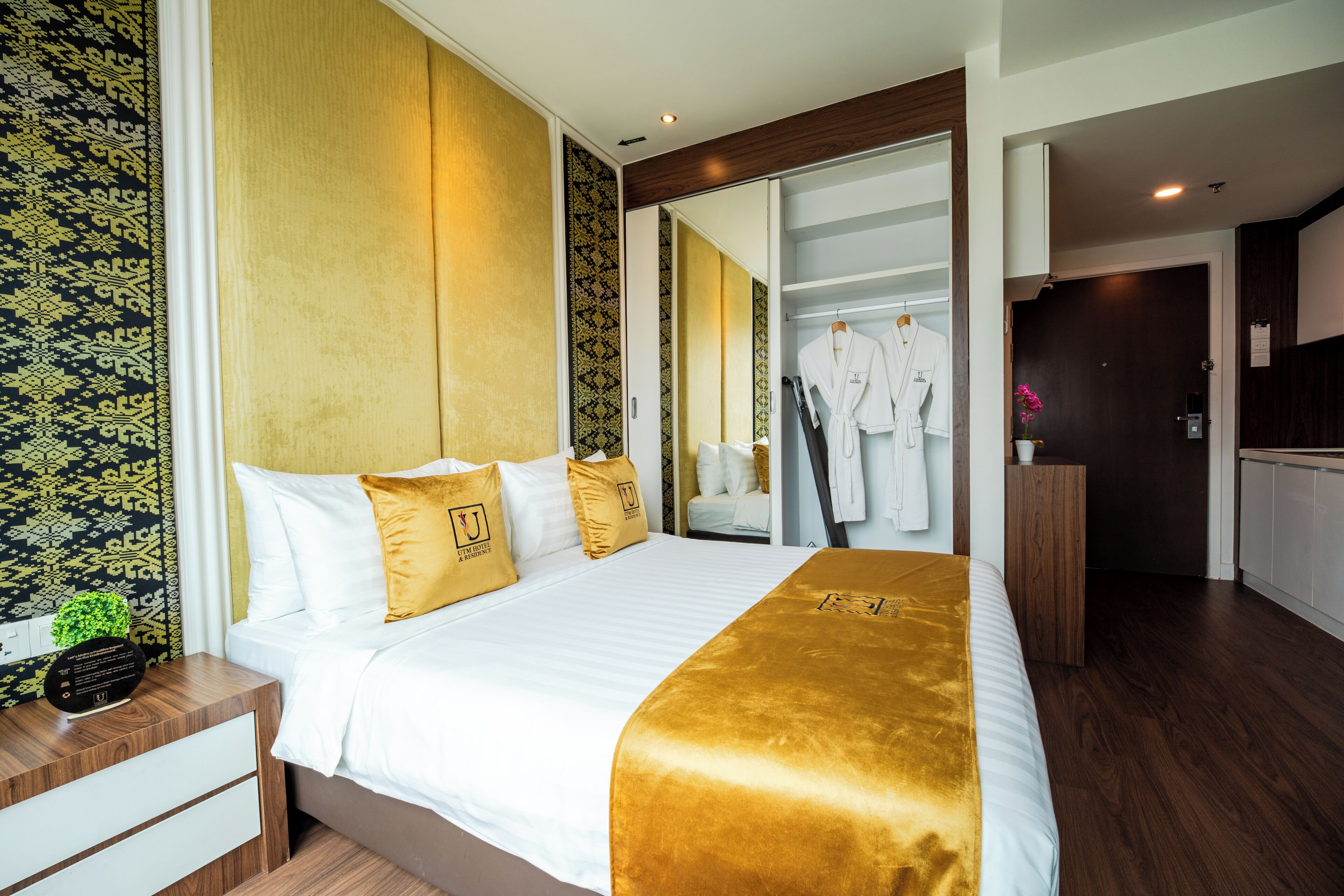 A hotel room with a bed, bedside tables, a wardrobe, and a mirror.