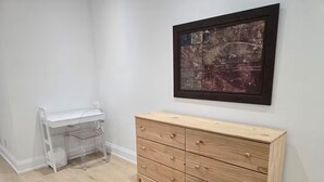 A room with a wooden dresser, a white desk, and a framed artwork on the wall. - Luxury Modern Cottage | 4 Ensuite Bedrooms | Sleeps 10 | Near Lake (Sundridge)