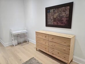 A room with a wooden dresser, a white desk, and a framed artwork on the wall. - Luxury Modern Cottage | 4 Ensuite Bedrooms | Sleeps 10 | Near Lake (Sundridge)