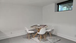 A dining area with a round table, four chairs, and a rug. - Luxury Modern Cottage | 4 Ensuite Bedrooms | Sleeps 10 | Near Lake (Sundridge)