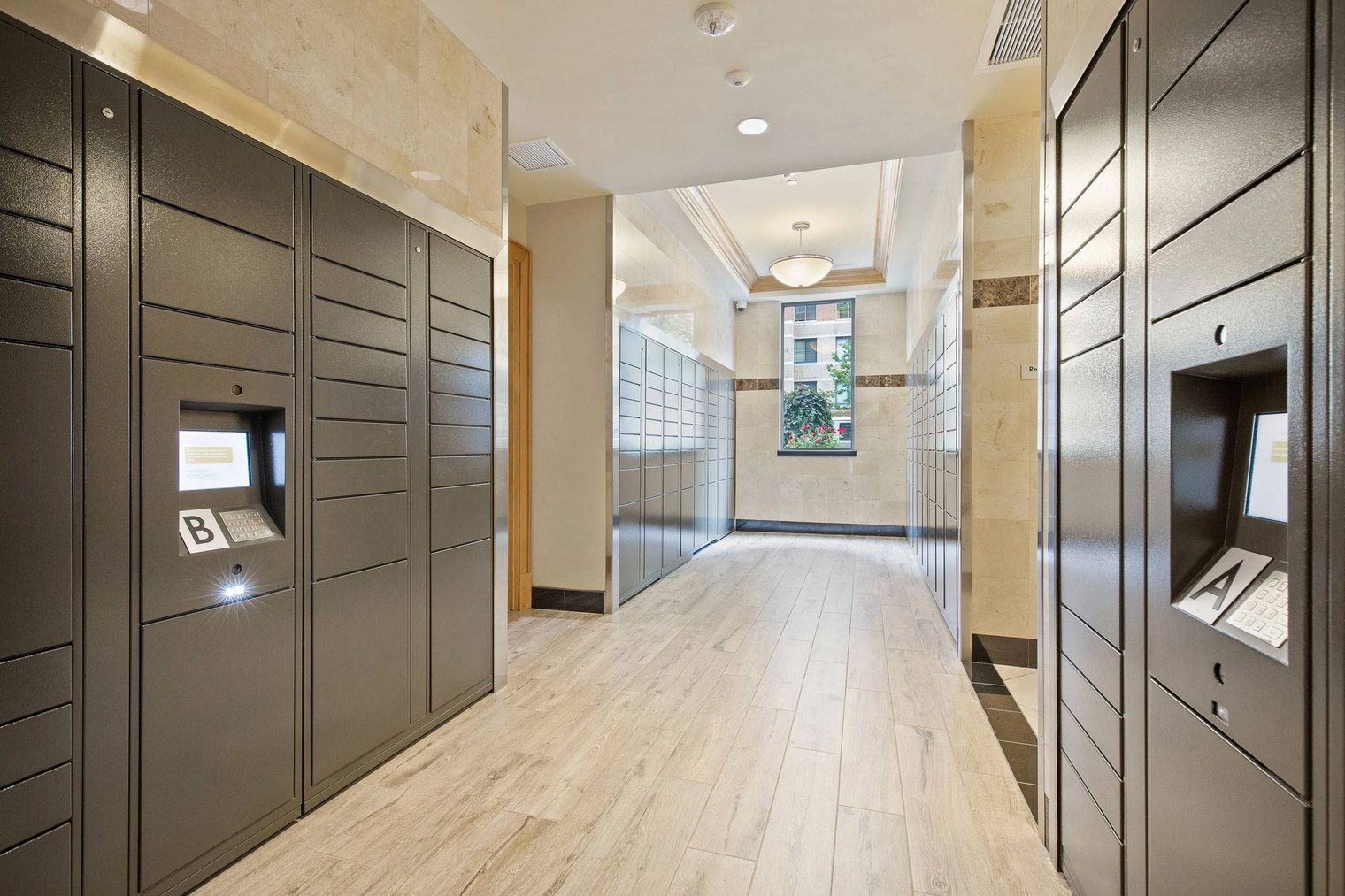 A hallway with lockers on both sides, a wooden floor, and a window at the end.