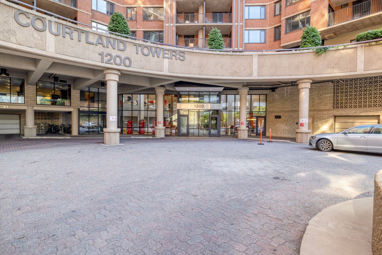 Un immeuble portant l’inscription « COURTLAND TOWERS 1200 », avec une façade en briques, de grandes fenêtres et un espace d’entrée abrité.