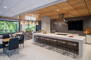 A modern kitchen with a large island, bar stools, and pendant lighting. - Blueground | Clarendon, pool, nr Arlington Cemetery (Arlington)