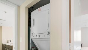 A laundry room with a washing machine, a dryer, and a small cabinet with a kettle. - Blueground | Clarendon, pool, nr Arlington Cemetery (Arlington)