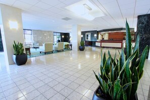 A spacious lobby with a reception desk, seating area, and potted plants. - Blueground | Clarendon, pool, nr Arlington Cemetery (Arlington)
