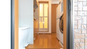 A narrow hallway with a wooden floor leading to a door with frosted glass panels. - Suncity Hakata (Fukuoka City Hakataku  Katakasu)