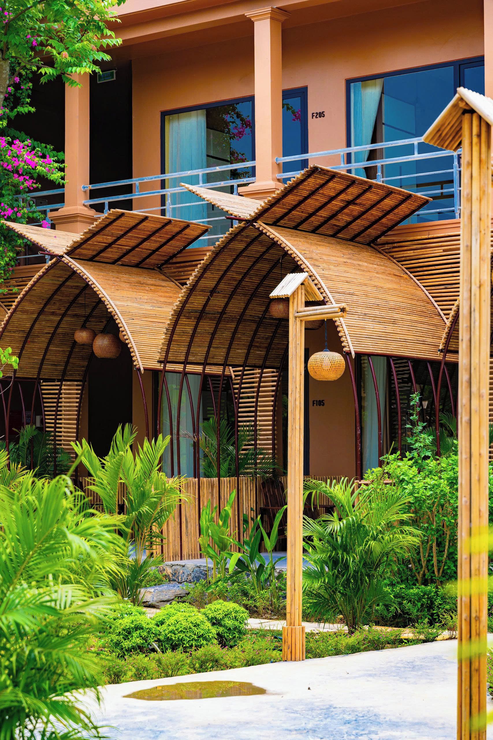 Un hotel de diseño moderno, con estructuras de bambú y abundante vegetación.