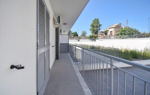 A balcony with a metal railing, a door, and an air conditioning unit on the wall. - Beautiful apartment in Casoria with WiFi (Casoria)