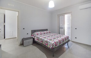 A bedroom with a bed, bedside table, and a wardrobe. - Beautiful apartment in Casoria with WiFi (Casoria)