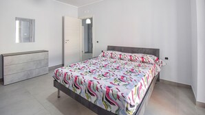 A bedroom with a bed, a dresser, a mirror, and a door. - Amazing apartment in Casoria with WiFi (Casoria)