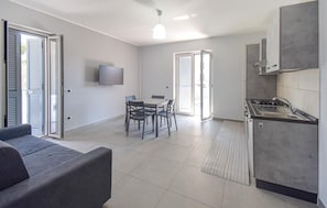 Eine moderne Küche mit integriertem Herd und einem Essbereich mit Tisch und Stühlen.