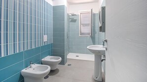 A bathroom with blue tiles, a shower, a toilet, and a bidet. - Amazing apartment in Casoria with WiFi (Casoria)