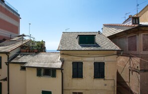 Ein Gebäude mit einem geneigten Dach, einem kleinen Fenster mit Rollläden und einer Antenne auf dem Dach.