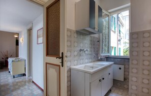 Eine Küche mit Spüle, Schränken und einem Fenster.