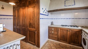 A kitchen with wooden cabinets, a gas stove, and a washing machine.