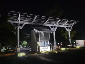 Ein modernes Gebäude mit einer Solaranlage auf dem Dach und einem Schild mit der Aufschrift 'KHAYA'.