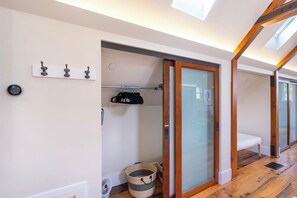 Ein modernes Interieur mit einer Schiebetür aus Glas, einem Kleiderhaken und einer kleinen Bank.