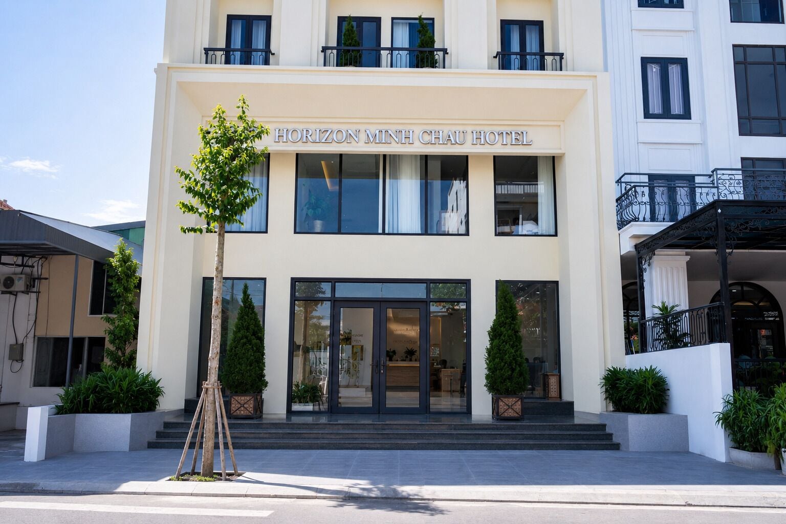 Das Hotel Horizon Minh Chau mit moderner Fassade, großen Fenstern und einladendem Eingang.